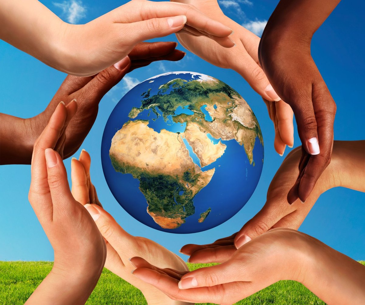 children's hands around an image of the world